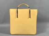 un sac à main jaune sur fond gris