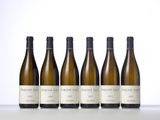 six bottles of wine lined up in a row on a table
