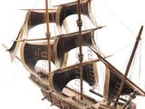 a wooden model of a ship on a white surface