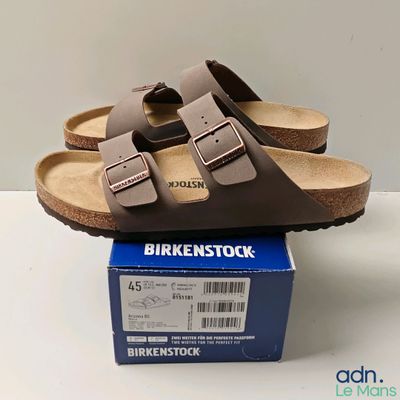 brown birkenstock sandals on top of a box on a white surface
