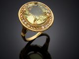 a close up of a ring with a green stone on a black surface