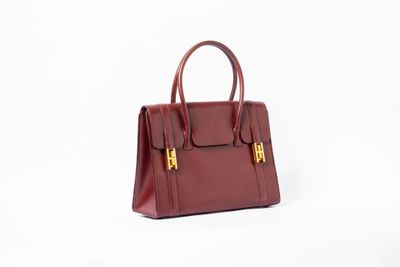 un sac à main rouge posé sur une surface blanche