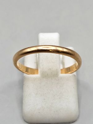 gros plan d'une bague en or sur une surface blanche
