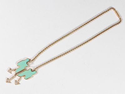 une image représentant un collier en or sur lequel figure une flèche verte