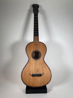 un gros plan d'une guitare posée sur un support, sur fond blanc