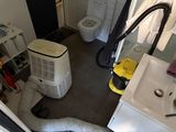une petite salle de bains équipée de toilettes, d'un lavabo et d'un climatiseur