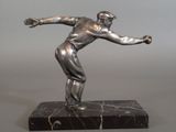 silver statue of a man throwing a ball on a marble base