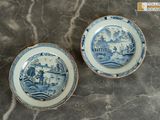 une paire d'assiettes bleues et blanches ornées d'un paysage