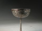 an antique silver goblet sitting on top of a white table
