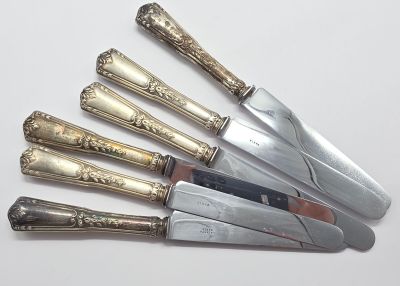 cinq couteaux posés les uns à côté des autres sur une table