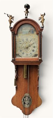 a clock that is hanging on the wall with angels on it