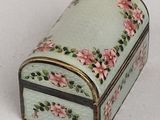 a small box with pink flowers on it on a white surface