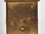 a small brass clock with a face on it