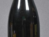 bottle of red wine with a label on it sitting on a table