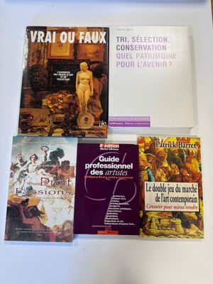 plusieurs livres posés sur une table, sur laquelle se trouve un ordinateur portable