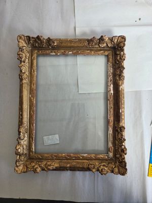un vieux miroir à cadre doré accroché au mur, à côté d'un drapeau bleu et blanc