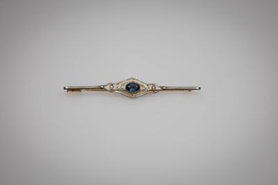 une broche en forme de barre sertie d'un saphir bleu et de diamants