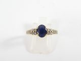 a close up of a ring with a blue stone surrounded by diamonds