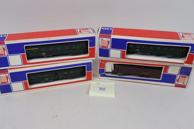 trois boîtes contenant des trains miniatures posées sur une surface blanche