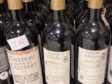 plusieurs bouteilles de vin sont alignées sur une étagère dans un magasin