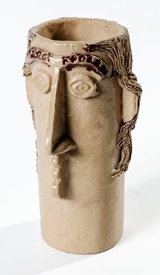 un vase sur lequel est représenté un visage sur le côté