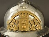 a silver and gold fireman ' s helmet on a stand