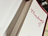 a book with a red cover that has a note inside of it