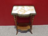 an antique table with a marble top on a red wall