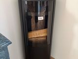 a small black cabinet with a sign on top of it