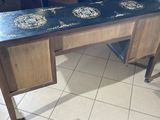 a wooden desk with a black and gold design on top of it