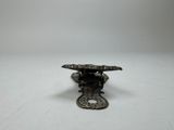 an image of a small metal object on a white surface
