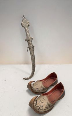 Deux paires de chaussures sont posées à côté d'un couteau sur une table.