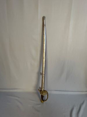 une épée argentée posée sur une table blanche, sur fond blanc