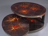 two round tables with red and orange designs on them on a white surface