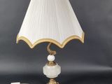 a white lamp with gold trim and a white shade