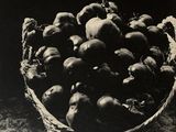 black and white photograph of a basket of fruit on a table