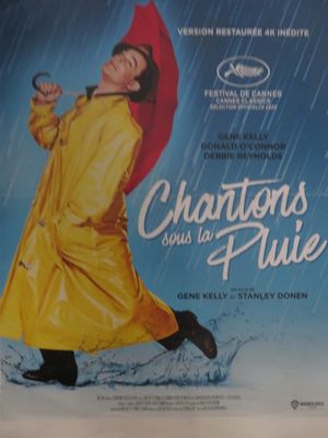 affiche de cinéma représentant une femme vêtue d'un imperméable jaune et tenant un parapluie