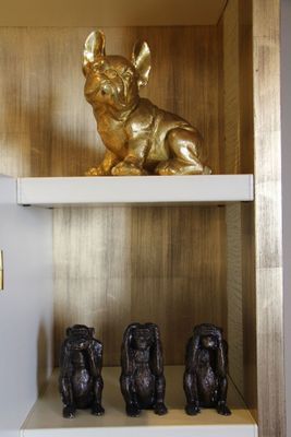 une statue en or représentant un chien, posée sur une étagère