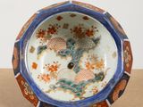 a blue and orange bowl sitting on top of a wooden table