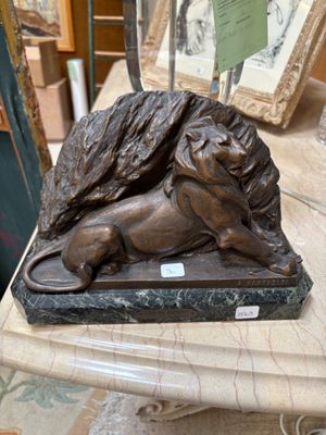 a statue of a lion laying on a marble table