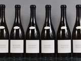 six bottles of wine lined up in a row on a table