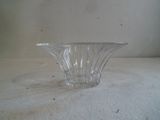 un bol en verre transparent posé sur une surface blanche