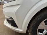 a close up of a white car parked in a parking lot