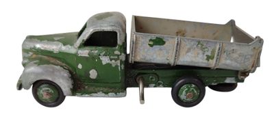 un petit camion jouet vert posé sur une surface blanche
