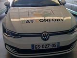 une voiture blanche garée dans un garage à côté d'autres voitures