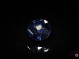 a close up of a blue and white stone on a black surface