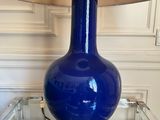 a blue lamp that is sitting on a glass table
