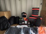 many bags of luggage sitting on top of a cardboard box