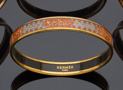 several different colored bracelets on a black surface with a black background