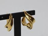 a close up of a pair of gold earrings on a black stand